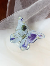 Load image into Gallery viewer, Matte Light Blue Butterfly Clip Infused with Real purple toned Flowers in Resin.