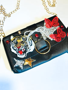 Faux Leather small clutch with fun patches and a classy gold chain for a strap.